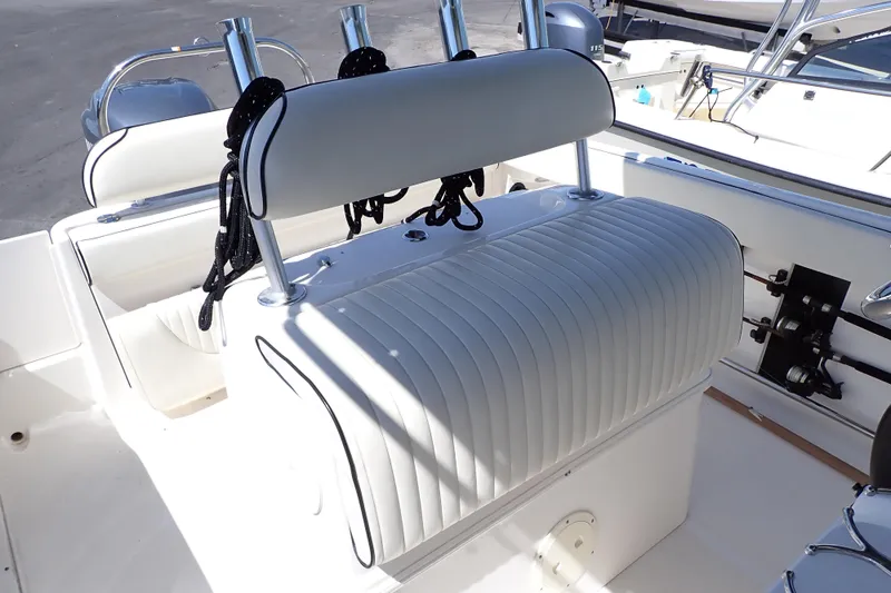 Slide: The Image of 2006 Robalo R220 Center Console boat interior with cushioned seating and fishing rod holders. - 8
