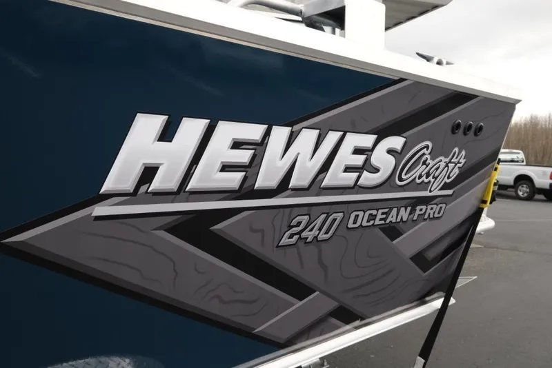 Slide: The Image of 2026 Hewescraft 240 Ocean Pro ET Hardtop boat logo on dark blue hull. - 6