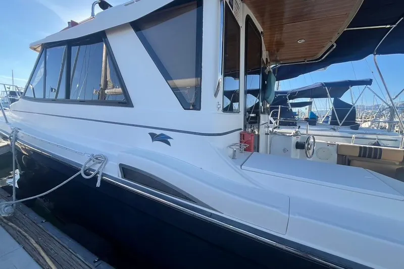 Slide: The Image of 2013 Cutwater C-28 boat docked at marina, showcasing sleek design and spacious deck. - 3
