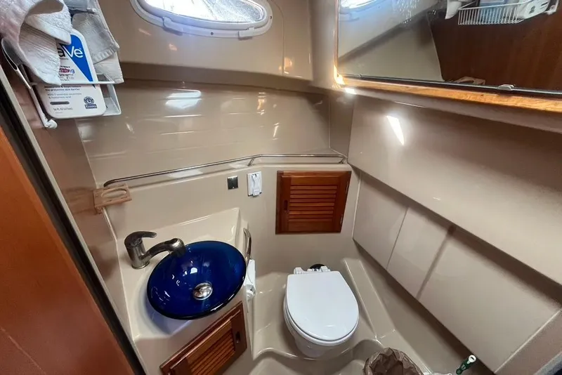 Slide: The Image of 2013 Cutwater C-28 boat bathroom with blue sink, toilet, and wooden cabinets. - 39