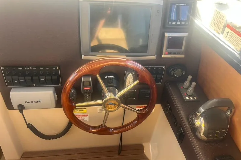 Slide: The Image of 2013 Cutwater C-28 helm with Garmin navigation, wooden steering wheel, and control panel. - 42