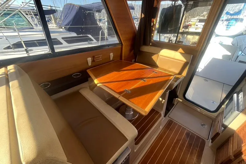 Slide: The Image of Interior of a 2013 Cutwater C-28 boat with wooden table and seating area. - 44