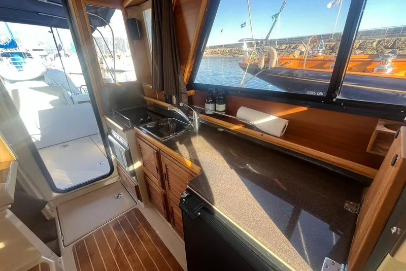 Slide: The Image of Interior of a 2013 Cutwater C-28 boat featuring a compact kitchen area with sink and storage. - 48