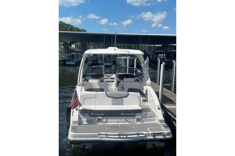 Slide: The Image of 2018 Chaparral 307 SSX boat docked at marina under blue sky. - 18