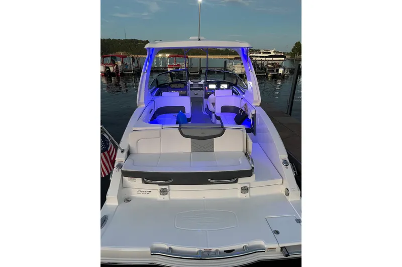 Slide: The Image of 2018 Chaparral 307 SSX boat docked, illuminated with blue interior lights at dusk. - 19