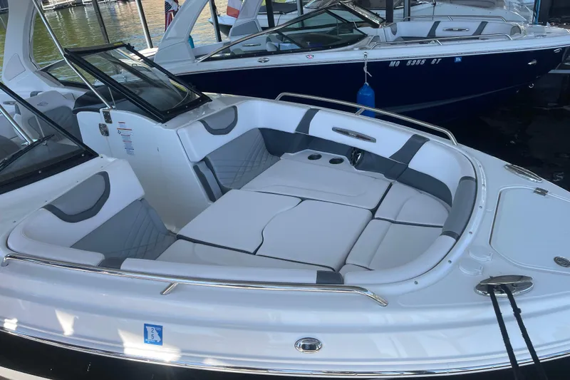 Slide: The Image of 2018 Chaparral 307 SSX boat with spacious seating and sleek design at a marina. - 9