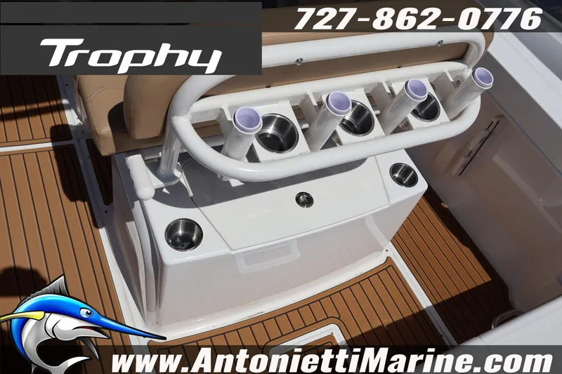Slide: The Image of 2026 Bayliner Trophy T22CC boat interior with rod holders and teak flooring. - 6