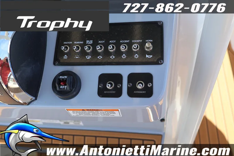 Slide: The Image of Control panel of 2026 Bayliner Trophy T22CC boat with switches and branding. - 8