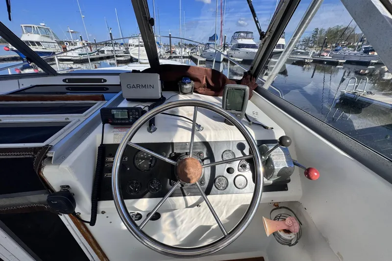 Slide: The Image of 1987 Luhrs Alura 30 boat helm with Garmin navigation, docked at marina. - 13