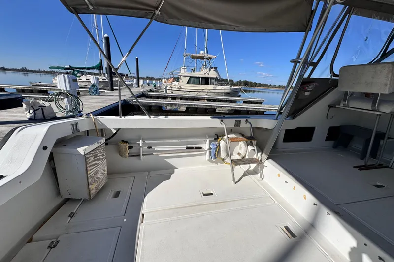 Slide: The Image of 1987 Luhrs Alura 30 boat docked at marina, featuring spacious deck and canopy. - 15
