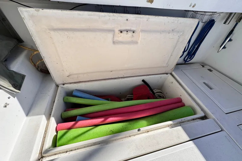 Slide: The Image of Open storage compartment on 1987 Luhrs Alura 30 boat with colorful pool noodles. - 19