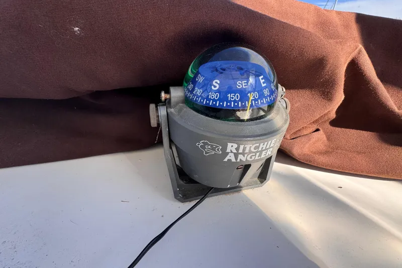 Slide: The Image of Ritchie Angler compass on 1987 Luhrs Alura 30 boat, with brown fabric backdrop. - 25