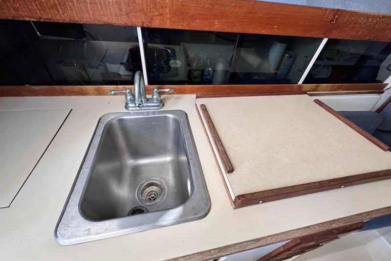 Slide: The Image of 1987 Luhrs Alura 30 boat kitchen sink and countertop with wooden trim. - 37