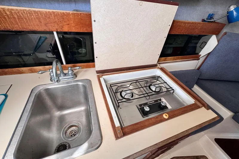 Slide: The Image of Compact kitchen area in a 1987 Luhrs Alura 30 boat with sink and stove. - 38