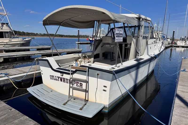 Slide: The Image of 1987 Luhrs Alura 30 boat docked, for sale, with canopy and "Gullywhumper" name. - 6