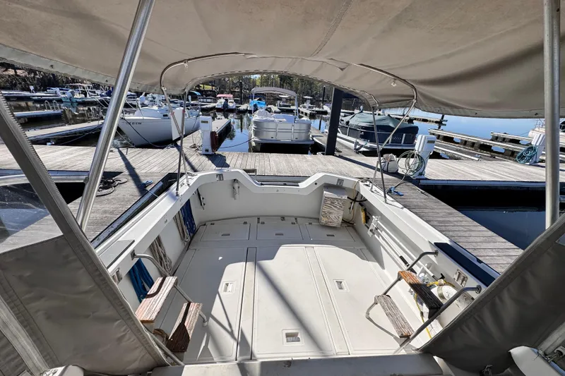 Slide: The Image of 1987 Luhrs Alura 30 boat docked at marina, featuring spacious deck and canopy. - 9