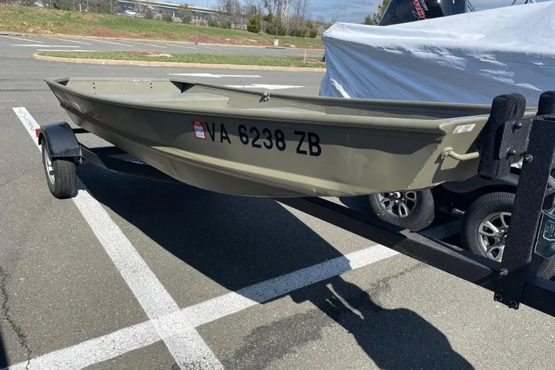 Slide: The Image of 2025 Tracker Grizzly 1236 Jon boat on trailer in parking lot. - 2