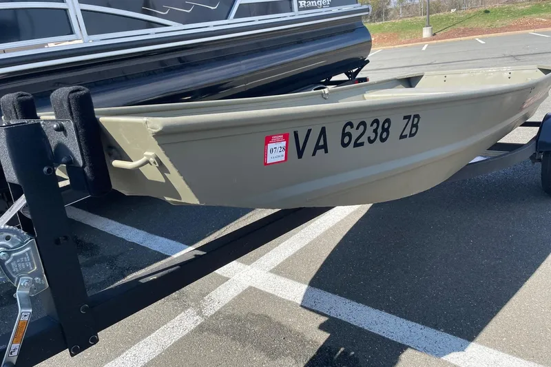 Slide: The Image of 2025 Tracker Grizzly 1236 Jon boat on trailer, parked in a lot. - 4