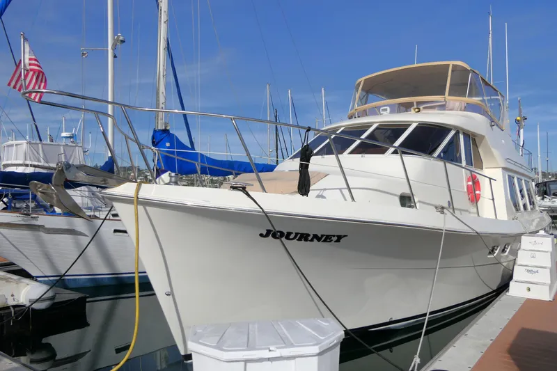 The Image of 1999 Hampton 490 Pilothouse yacht named "Journey" docked at a marina. - 0