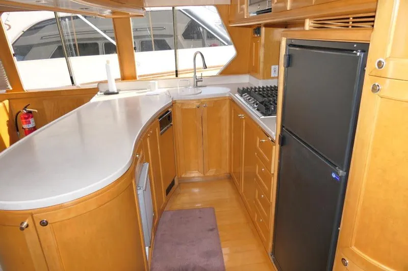 Slide: The Image of Interior of 1999 Hampton 490 Pilothouse yacht kitchen with wooden cabinetry and modern appliances. - 10