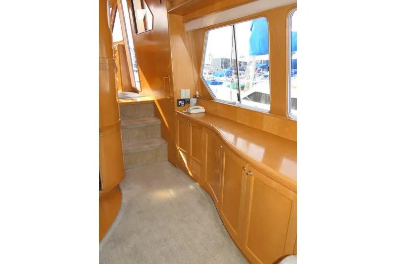 Slide: The Image of Interior of 1999 Hampton 490 Pilothouse yacht with wooden cabinetry and carpeted stairs. - 16