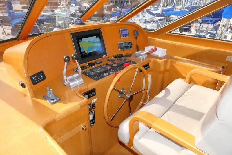 Slide: The Image of 1999 Hampton 490 Pilothouse helm with navigation equipment and wooden steering wheel. - 18