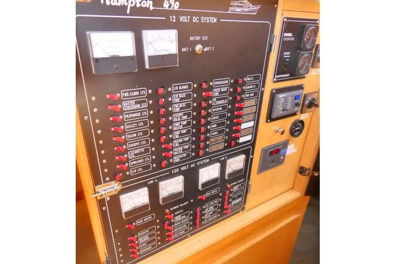 Slide: The Image of Control panel of a 1999 Hampton 490 Pilothouse boat, featuring electrical systems and gauges. - 21