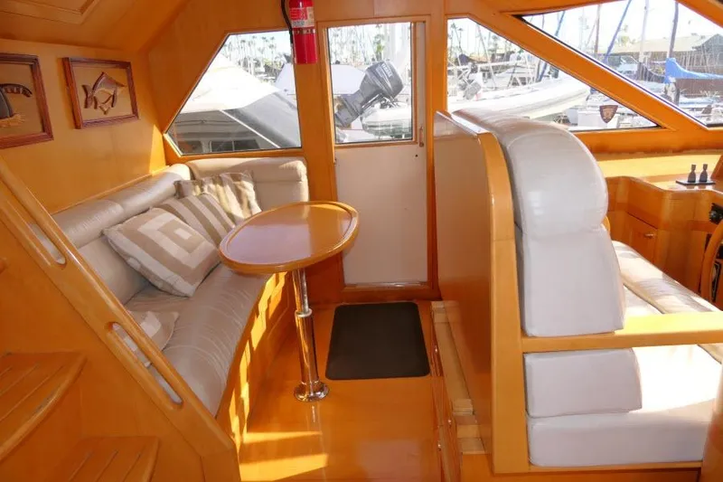 Slide: The Image of Luxurious interior of 1999 Hampton 490 Pilothouse yacht with plush seating and wooden accents. - 23