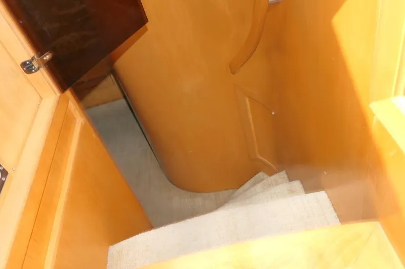 Slide: The Image of Staircase inside 1999 Hampton 490 Pilothouse yacht with wooden finish. - 25