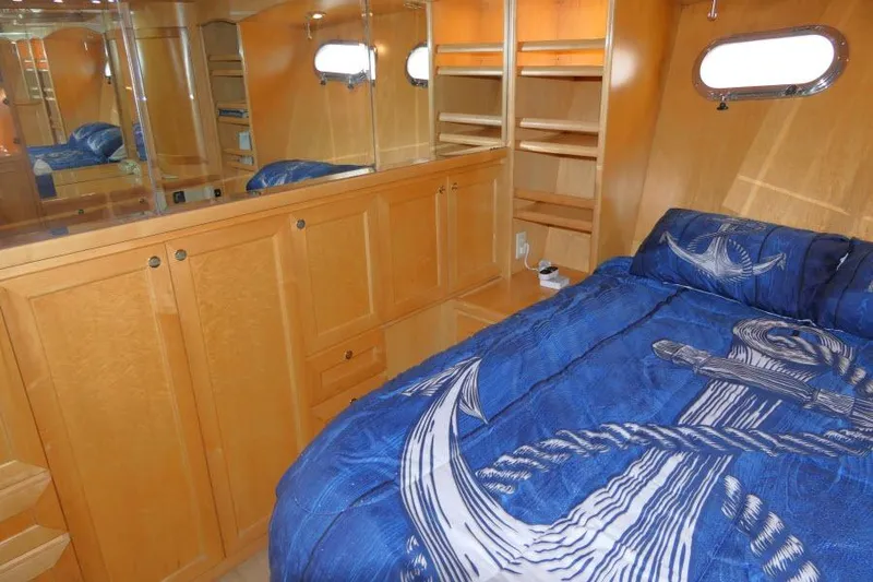 Slide: The Image of Cozy bedroom in 1999 Hampton 490 Pilothouse with nautical-themed bedding and wooden cabinetry. - 27