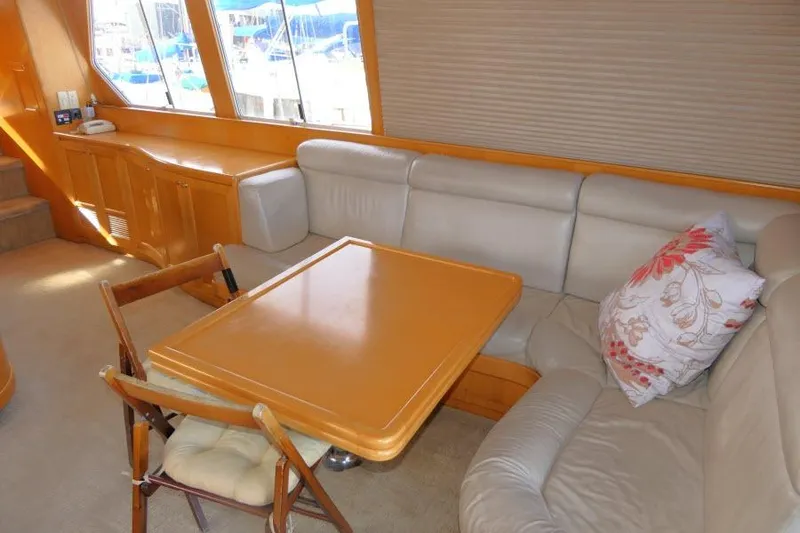 Slide: The Image of Interior of 1999 Hampton 490 Pilothouse with cozy seating and wooden table. - 3