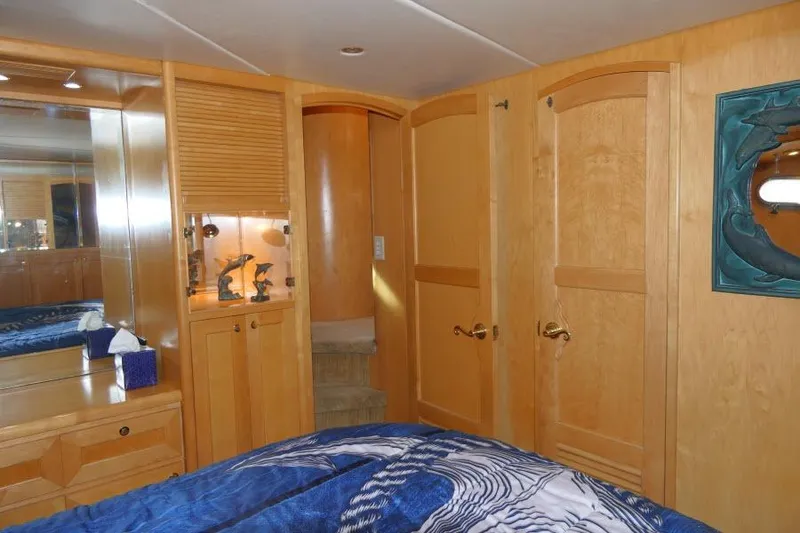 Slide: The Image of Luxurious 1999 Hampton 490 Pilothouse yacht bedroom with wooden cabinetry and nautical decor. - 32