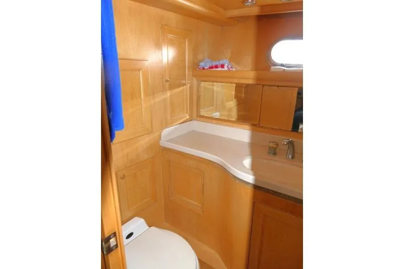Slide: The Image of Bathroom interior of 1999 Hampton 490 Pilothouse yacht with wooden cabinetry and modern fixtures. - 33