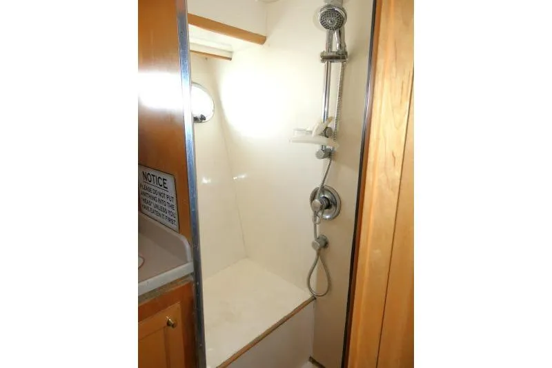 Slide: The Image of Shower area in 1999 Hampton 490 Pilothouse yacht, featuring modern fixtures and wooden accents. - 34