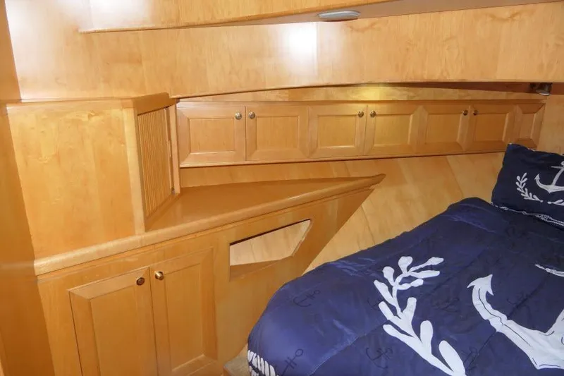 Slide: The Image of Cozy cabin interior of 1999 Hampton 490 Pilothouse with wooden cabinetry and nautical bedding. - 37
