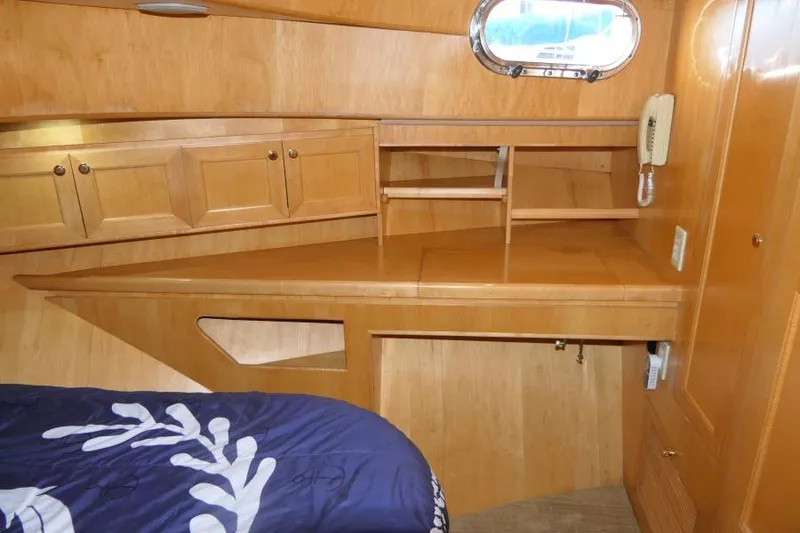 Slide: The Image of 1999 Hampton 490 Pilothouse cabin interior with wooden cabinetry and nautical decor. - 39