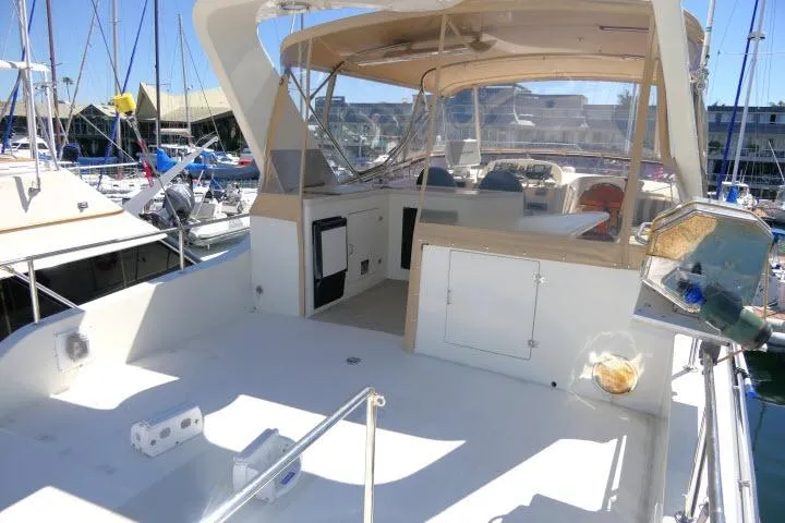 Slide: The Image of 1999 Hampton 490 Pilothouse yacht with spacious deck and covered helm at marina. - 43