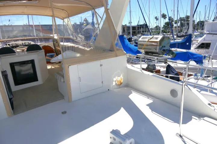Slide: The Image of 1999 Hampton 490 Pilothouse yacht deck with marina view and outdoor seating area. - 44