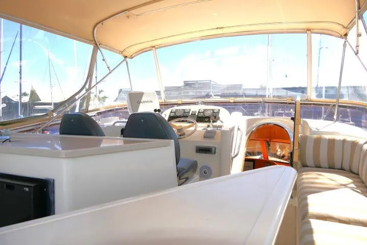 Slide: The Image of 1999 Hampton 490 Pilothouse yacht interior with helm, seating, and navigation equipment. - 45
