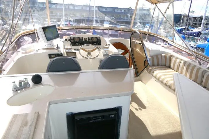 Slide: The Image of 1999 Hampton 490 Pilothouse yacht interior with helm, seating, and navigation equipment. - 46