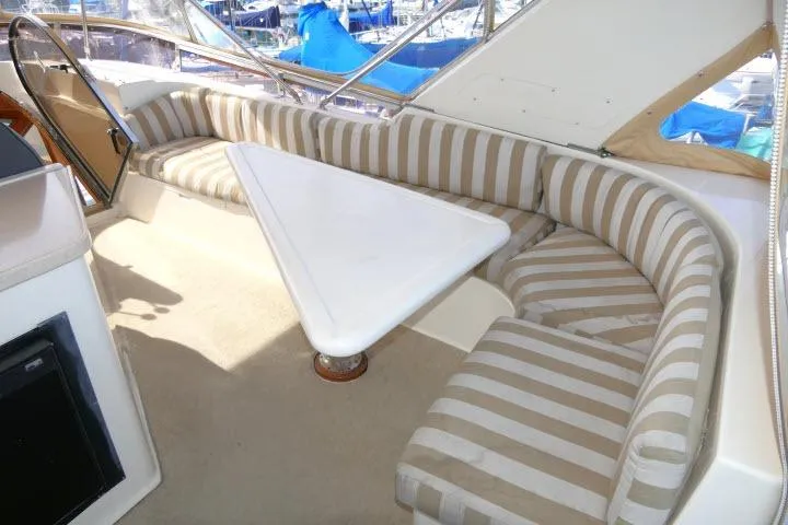 Slide: The Image of Interior of 1999 Hampton 490 Pilothouse with striped seating and triangular table. - 47