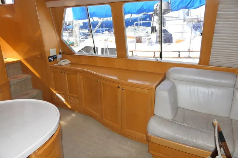 Slide: The Image of Interior of 1999 Hampton 490 Pilothouse yacht with wood cabinetry and leather seating. - 5