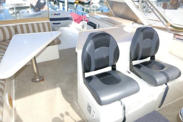 Slide: The Image of Interior of a 1999 Hampton 490 Pilothouse boat with seating and table. - 52