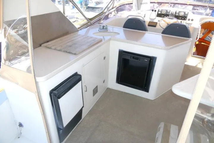 Slide: The Image of Interior of 1999 Hampton 490 Pilothouse yacht with kitchenette and seating area. - 56