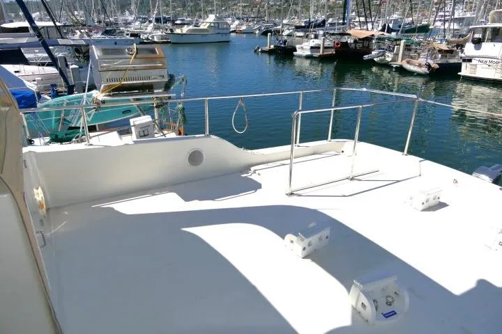 Slide: The Image of 1999 Hampton 490 Pilothouse yacht deck at marina with boats in background. - 59