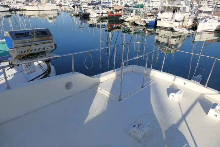 Slide: The Image of Deck view of a 1999 Hampton 490 Pilothouse yacht in a marina. - 60