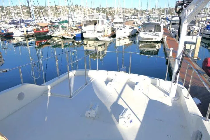 Slide: The Image of 1999 Hampton 490 Pilothouse yacht docked in a marina with other boats. - 62