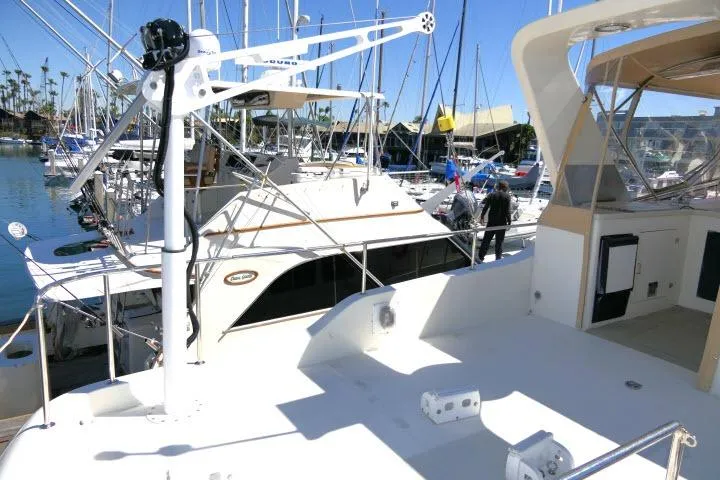Slide: The Image of 1999 Hampton 490 Pilothouse yacht docked in a marina with clear blue skies. - 65