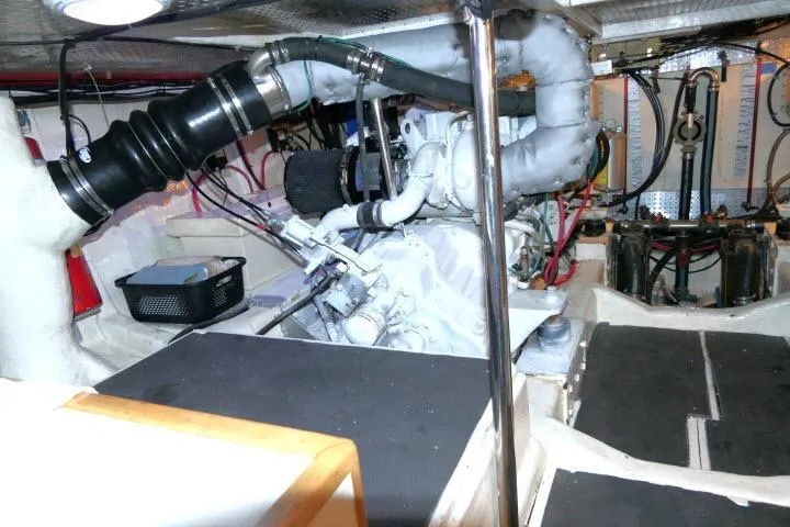 Slide: The Image of Engine room of a 1999 Hampton 490 Pilothouse yacht, showcasing mechanical components and wiring. - 76