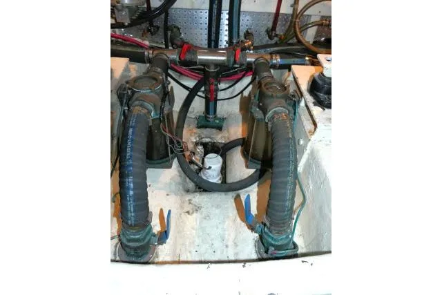 Slide: The Image of Engine room of 1999 Hampton 490 Pilothouse with visible hoses and valves. - 79